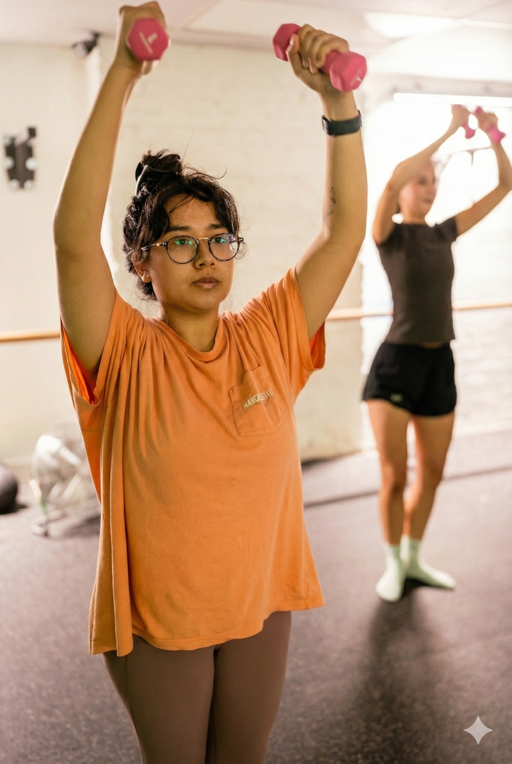 Barre class participant using weights for upper body work